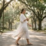 Woman walking in a lightweight dress for humid summer weather on a tree-lined Southern street.