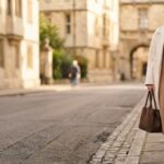 Woman in a camel knit midi dress and cream coat demonstrating quiet luxury dress outfit ideas women can wear daily