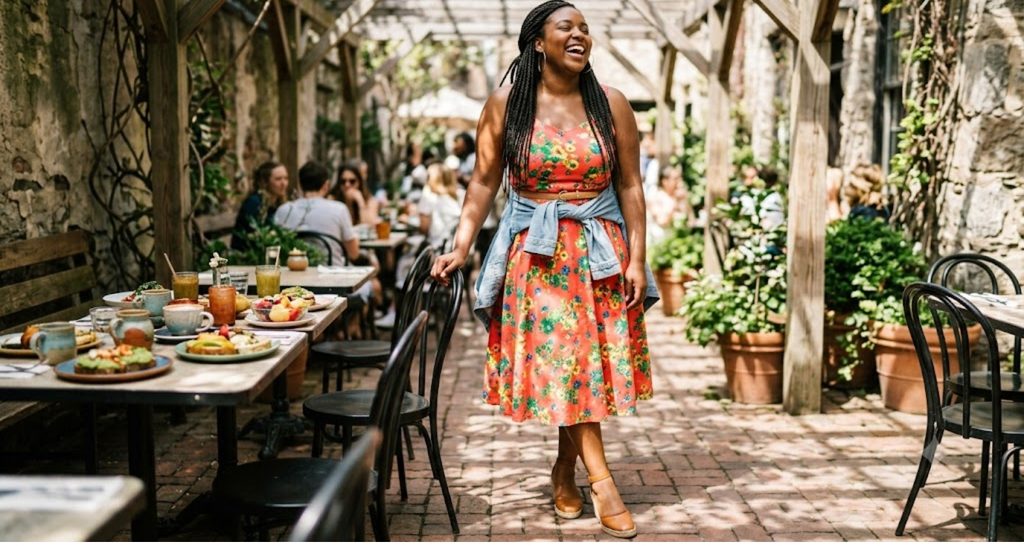 Plus size woman in a bright floral fit and flare midi dress with espadrille wedges at brunch